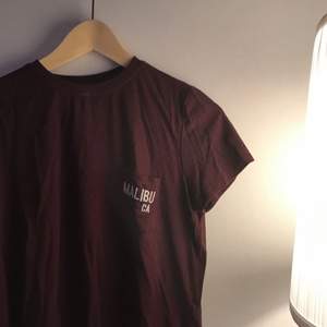 Vinröd t-shirt från Pullandbear. Mycket sparsamt använd. Supersnygg högre skurning på ”kragen”.
