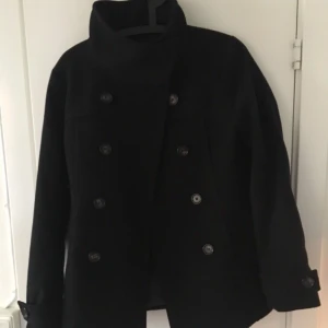  - Svart kappa med krage och knappar