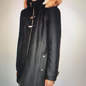  - Bomullsblandat Parka med pälshuva. Avtagbar huva. Flik fickor med knapp. Lång ärm med knapp manschetter.  Blixtlåsstängning på framsidan. Förslutning med dubbla spännen.  Sidolängd 56.0 cm Bakre längd 78.0 cm 