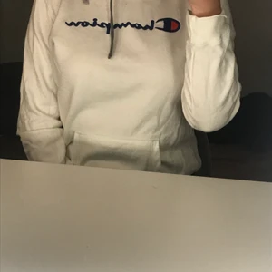 Champion hoodie i vitt - Säljer nu denna snygga hoodie ifrån champion. Hoodien har snygga detaljer så som märket på armen samt snörningen i sidan istället för på mitten av kragen. Hoodien är i storlek XL men skulle säga att den är mer M då den krymt i tvätten. Frakt tillkommer