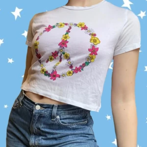 Skitsnygg croppad tee! - Skitsöt croppad t-shirt med ”slits” från Monki! Väldigt gullig y2k vibe på grund av trycket! Använd Max 2 ggr, nyskick. Perfekt nu inför våren och sommaren☀️☀️ 50 kr + frakt!