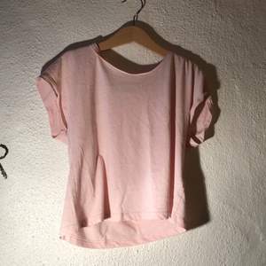 Rosa croppad t-shirt från H&M med uppvikta ärmar. Storlek 134/140. Bra att dansa i.