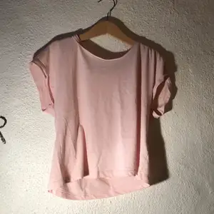 Rosa croppad t-shirt från H&M med uppvikta ärmar. Storlek 134/140. Bra att dansa i.