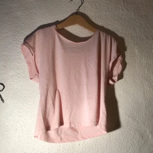 Rosa t-shirt - Rosa croppad t-shirt från H&M med uppvikta ärmar. Storlek 134/140. Bra att dansa i.