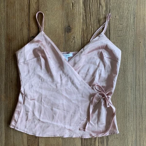 NellyOne - Supersöt satin topp från Nelly som tyvärr inte passar längre och är i bra skick, frakt tillkommer 