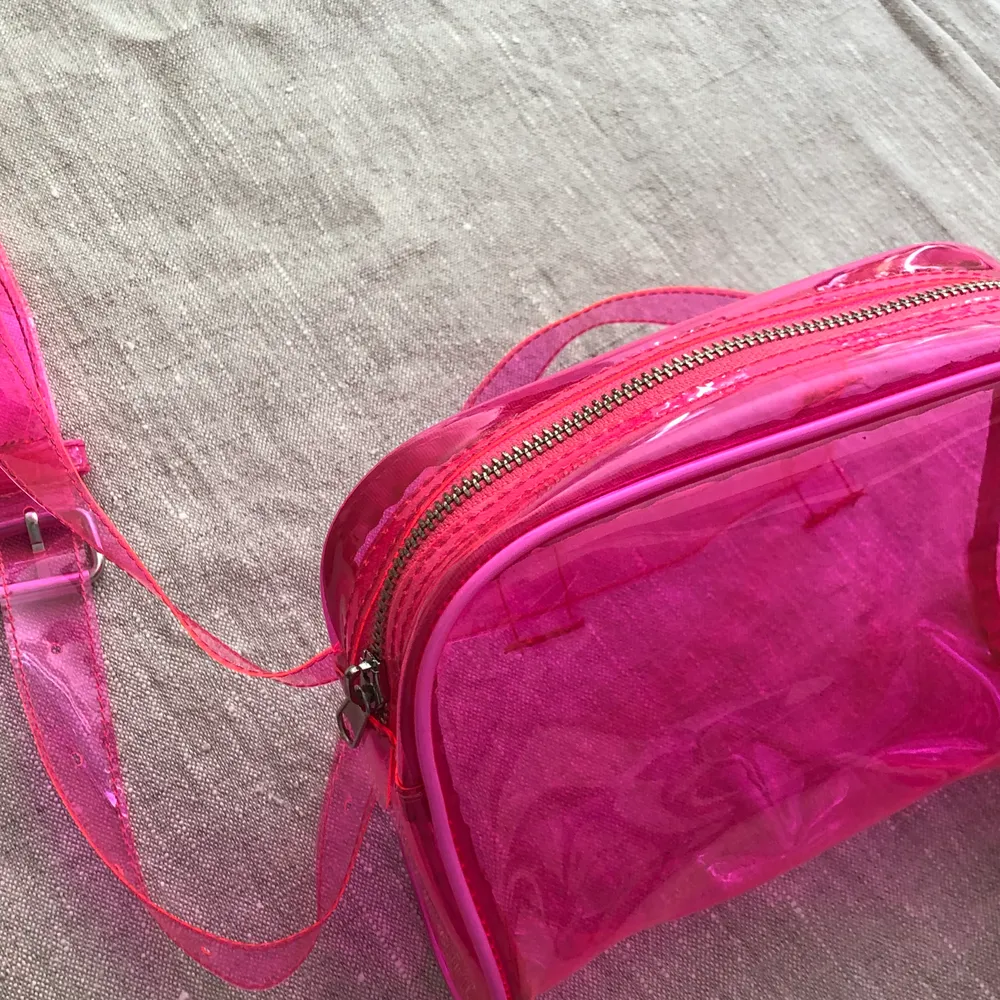 Rosa genomskinlig väska, köpt här på plick men väldigt bra skick. Köparen betalar frakten 💕. Väskor.