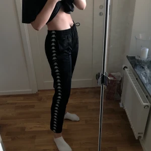 Kappa popper byxor - Ett par knappt använda popper pants från kappa. Jätte fint skick, dock inga lappar kvar. Jätte bekväma och snygga men lite för korta för mig, är 177cm. Frakt ingår ej, kan mötas upp i karlstad :)