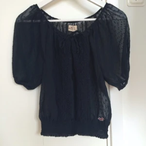  - Hollister blus i nyskick. Passar storlek XS-S. Blusen är lite transparent och prickig samt har resår i midjan vilket gör att man kan ha den som en croptop eller heltäckande.  