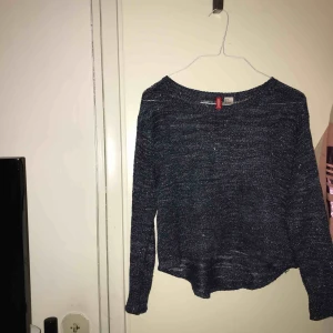  - En lite kortare stickad blus som är blå och med lite silver glitter