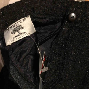  - Svart glittrig kjol från Jennifer By Adelsten. På baksidan är en liten slits och lappen sitter kvar. 