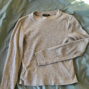  - Grå tunn ribbad tröja från Monki. Långärmad. Mellankort, jättesnygg till högmidjade jeans/byxor!💛