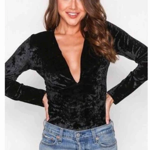  - En svart sammets body med en djup v-ringning från NLY Trend. Aldrig använd och nypris var 299kr Köpare står för frakt.