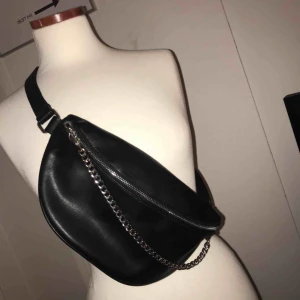  - Detta är en midjeväska i svart skinn (oäkta). Den är köpt i butiken forever21 och den är använd endast 1 gång. Går att spänna in banden och spänna ut.