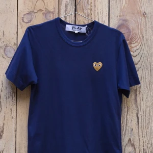 Commes des garcons - Säljer denna superfina Commes des garcons T-shirt med guldigt hjärta i stl S, köpt på Paul and Friends på NK för 2 år sen. Tröjan är knappt använd och är i nyskick!  Kan bjuda på frakten vid smidig affär🥰