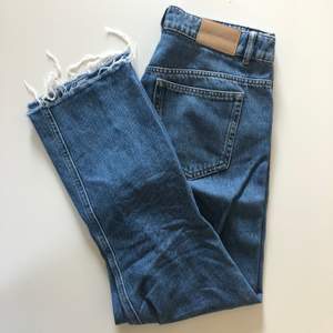 Raka jeans som är något croppad med slitningar nedtill från Carin Wester. Mörk jeansblå färg. Väl använda men inga fel på dem.