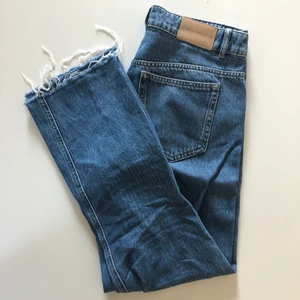 Raka jeans strl 40 - Raka jeans som är något croppad med slitningar nedtill från Carin Wester. Mörk jeansblå färg. Väl använda men inga fel på dem.