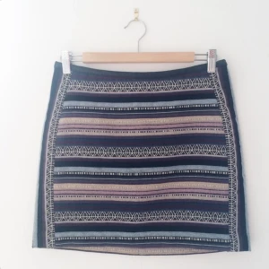  - Mönstrad kjol från H&M med kantband i läder. Dragkedja baktill. Något kortare fram. Aldrig använd då den är för liten för mig. 