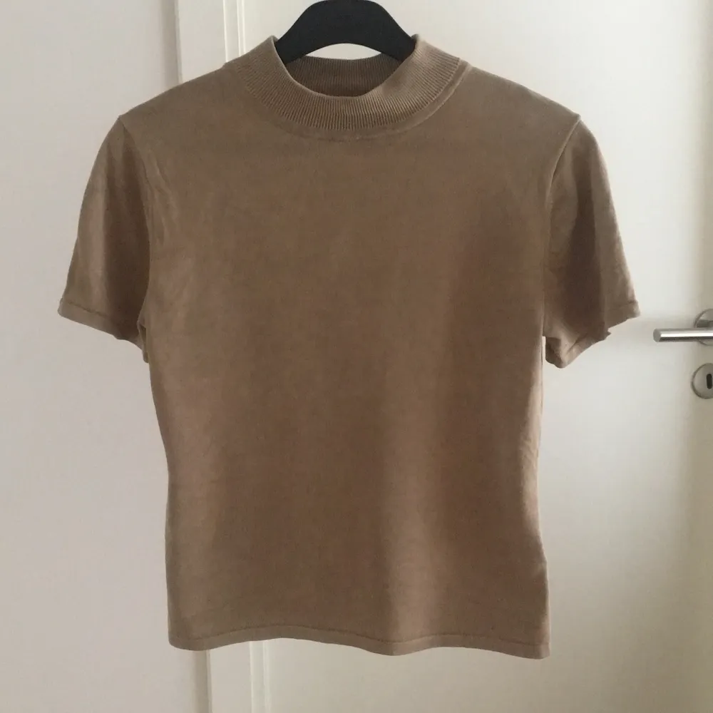 Väldigt fin t-shirt med perfekt polokrage i beige som sitter tight på kroppen. En favorit som tyvärr inte kommer till användning längre. Är storlek S men skulle säga att den är mer en XS. Priset är exklusive frakt 💕. T-shirts.