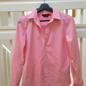  - Rosa och vitrandig skjorta från Ralph Lauren. Använd sparsamt ett fåtal gånger. Storlek 8, vilket motsvarar 38. På grund av slimfit passar det också 36. 