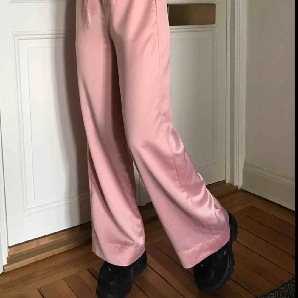 Sååååå fina rosa satinbyxor från Missguided, använda ett fåtal gånger men dom är som nya! Säljer pga inte min stil längre. Jag har sytt upp dom så det går att sprätta upp och få dem längre, jag är 170cm. Möts upp eller fraktar, köpren betalar frakt 💖💖💖. Jeans & Byxor.