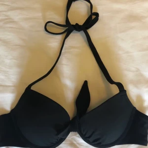 Svart push-up bikiniöverdel  - Svart push-up bikiniöverdel med justerbar knytning i nacken, vilket gör det möjligt att bestämma själv hur mycket man vill ha så att säga. köpare står för frakt, kontakta för fler bilder eller frågor