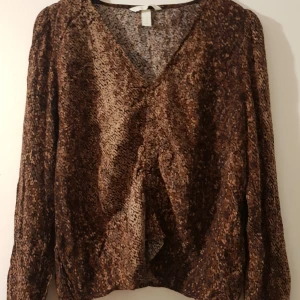 HM topp stl 42/44 - Fin topp från HM i stl 44, liten i stl mer som 42 Använd fåtal ggr i fint beg skick. Djur finns i hemmet. Fraktpriset är ca pris.