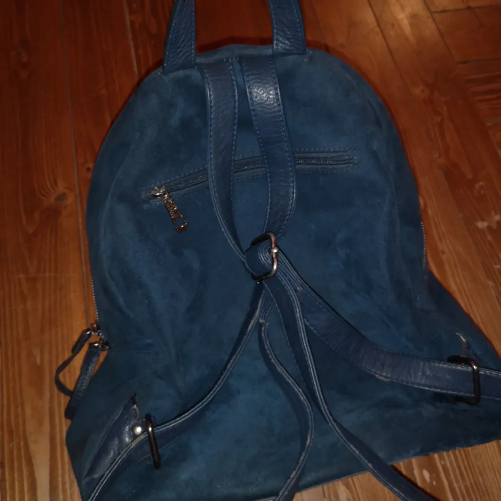 Fin och väldigt rymlig ryggsäck i mocka med 6 st fack ! Den har en del slitningar på utsidan (bild 1) från att jag har haft pins på men annars i hyfsat bra skick🌞. Väskor.