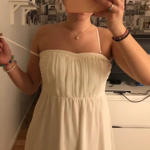 Vit klänning från Vila - En vit klänning från Vila i storlek XS. Använd fåtal gånger, vid skolavslutning. Axelband som går att ta av och på. Inga synliga skador förutom spännet som börjar lossna, som syns på bilden. 