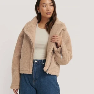 Teddy Biker Jacka (36) - En beige teddypäls  jacka som inte använts mer än 3 gånger! Köpt från NA-KD för 899 kr. Fickor med dragkedja på sidan samt dragkedja vid ärmarna. Bra kvalite. Kan användas på vinter såväl som vår/höst