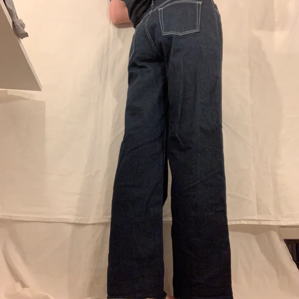 Mörkblå jeans med vita sömmar från Nelly. Fint skick. Högmidjade och utsvängda / baggy. Jeans & Byxor.