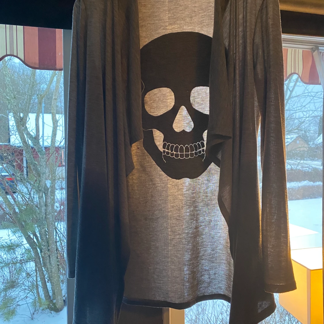 Grå kofta med svartglittrig dödskalle på ryggen