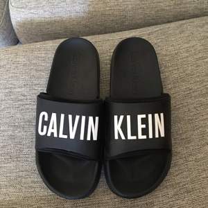 Calvin Klein tofflor i bra skick. Köpta i början av sommaren använda fåtal gånger. Köparen står för frakt 