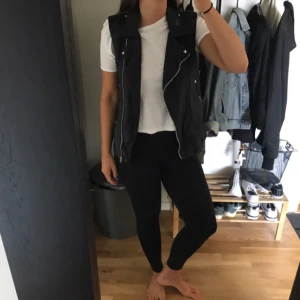  - Snygg "skinn"väst. Riktigt snyggt att kombinera med t-shirts eller hoodies nu till hösten :)  Köparen står för frakten:)