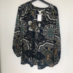  - Blommig blus/skjorta H&M. Aldrig använd. Stl: 38