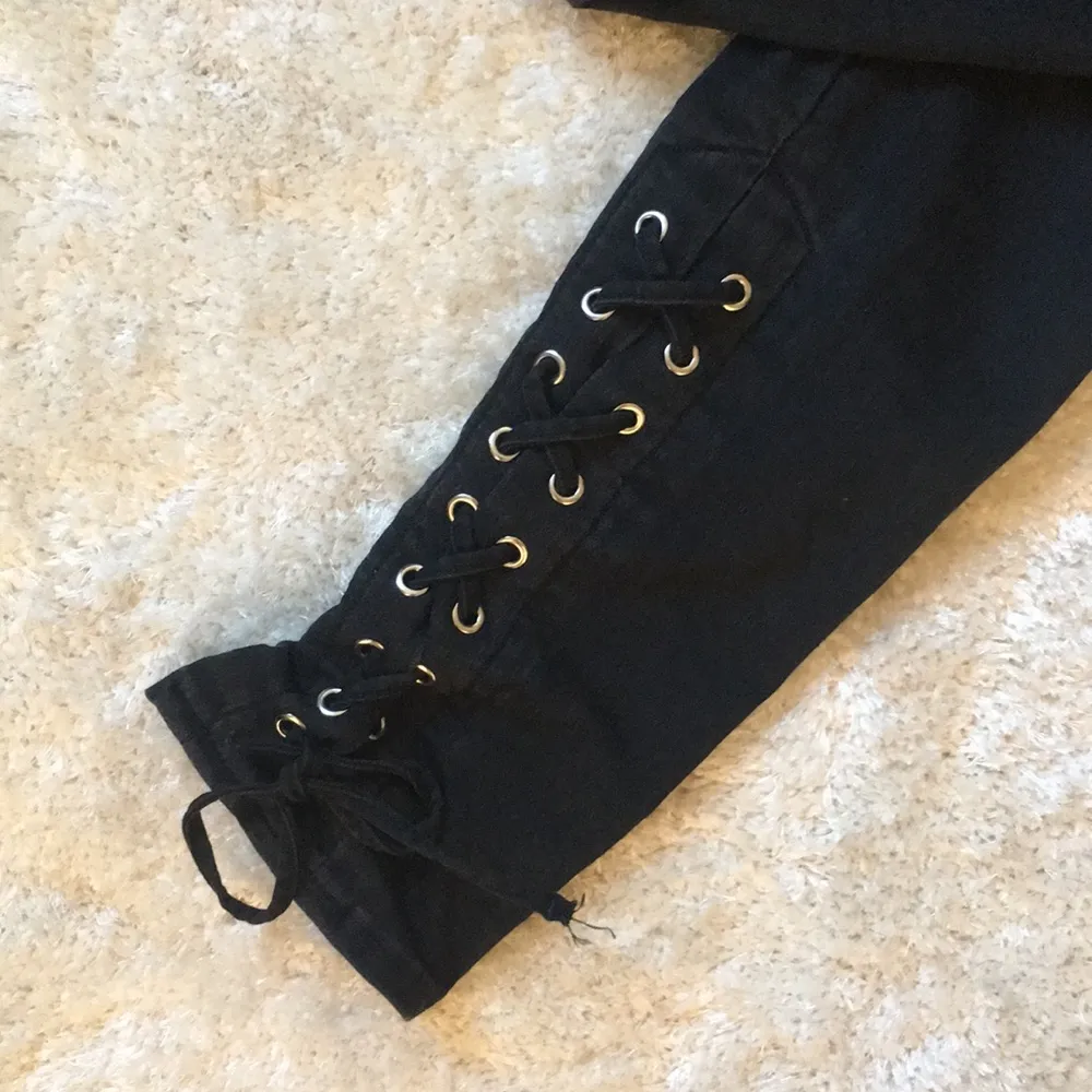 Svarta jeans med knytdetalijer vid anklarna och fickor där bak, använda bara några gånger, passar bra till någon med storlek 25-26 i jeans . Jeans & Byxor.