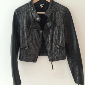  - Jacka i fakeläder i ormimitation. Köpt på H&M divided för några år sedan. Är använd rätt så mycket men lika fin för det. Kan mötas upp och tar swish.