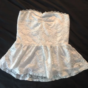  - En vit töjbar topp utan ärmar med volanger längst ner Möts upp i Stockholm eller fraktar Frakt står köparen för själv 