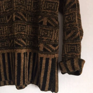  - Stickad tröja med ett mönster som ger en spännande vintage känsla som påminner om Egypten. Otroligt charmig.  Har dock ett litet hål uppe i halsen men det går lätt att fixa. 