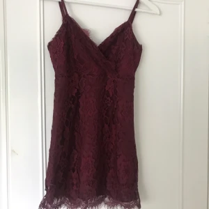  - Röd klänning i spets med dragkedja i ryggen. Smala band. Använd cirka 3 gånger, bra skick. Ganska kort i storleken.