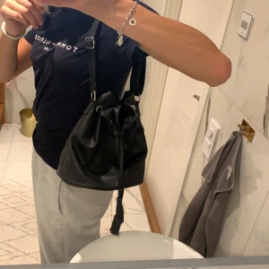 Svart väska med silverdetaljer - En svart väska med reglerbart band över axeln. Använd en gång men får inget bra tillfälle att använda den. Ett relativt stort fack med ett litet i. Köparen står för frakt💞🌸