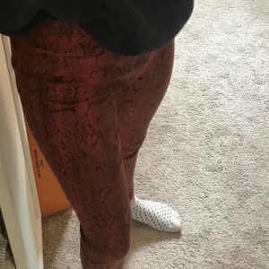 Byxor från stradivarius - Ett par sjukt coola byxor från stradivarius. De är i rött ormmönsyer och är i storlek 36
