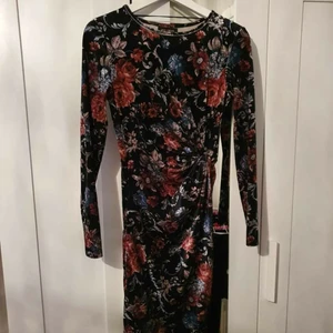 Blommig sammet klänning - Säljer min fina sammetsklänning som jag endast använt en gång. Storlek M och sitter som en smäck, en detalj är att det är som omlott klänning o en "knut" vid midjan. Skickar endast med spårbar och säker frakt som kostar 63 kr för bådas skull. 