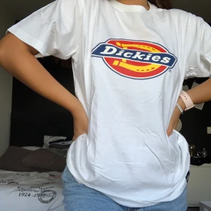 Dickies vit logo - Dickies vit logo T-shirt. Inte mycket använd men trycket e lite avskavt, se bild! Medium sitter snyggt på mig som e S om man vill ha oversized look. 