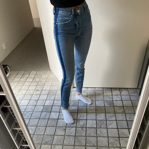 Jeans Gina Tricot  - Sköna högmidjade jeans från Gina Tricot med mörkblå detalj på sidan av båda benen! Använda endast en gång. Pris kan diskuteras och frakt tillkommer 💕