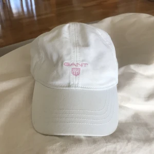 Gant keps  - Vit gant keps med rosa text. Köpt på Nk i Göteborg 💓 bra skick men är lite gul vid tinningen och på insidan. Någon fläck så den hade behövt en tvätt. Storlek XL barnstorlek 56-58 cm. 130 kr. Skriv privat för mer bilder 😘
