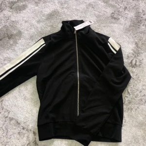 Kofta i strl XS - Lite tunnare kofta med vita streck på ärmarna köpt från Gina tricot, aldrig använd med prislapp på. Ordinarie pris var 349kr säljes för 160kr + frakt.