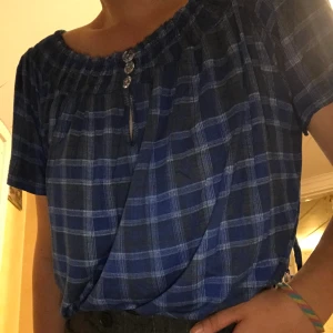 Blå top strl L/XL - Söt rutig blå top/blus storlek L/XL. Knappt använd, hällor för skärp, elstiskt tyg 💙 (frakt ingår ej)
