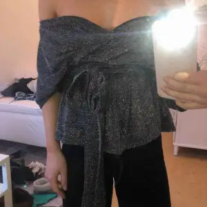 Silverglittrig topp från bikbok. Går att bära både off shoulder och inte. Banden är långa och går att knyta fram eller bak. Använd 1 till 2 gånger. Inga tecken på användning. Köparen betalar frakten. 