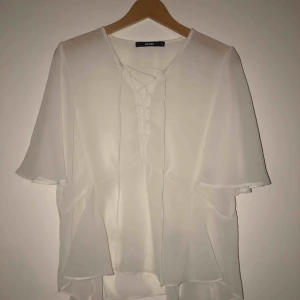  - vit blus med snörning, storlek L. Frakt tillkommer!