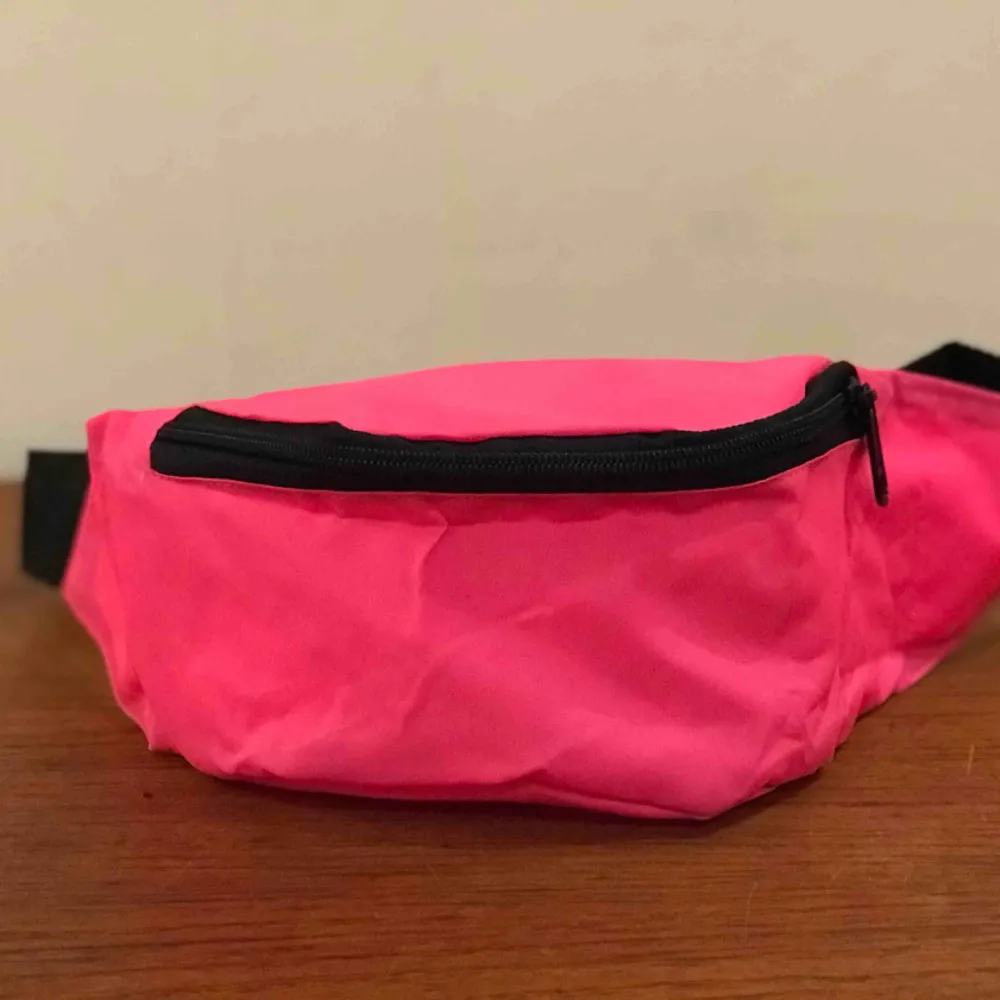 Magväska i enkel nylon modell från 90-talet.  Har ett litet parti med denna rosa neon färg och även svart och mörkblå. . Väskor.